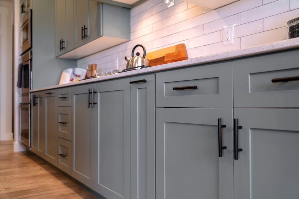 Custom grey shaker kitchen cabinets with white tile backsplash