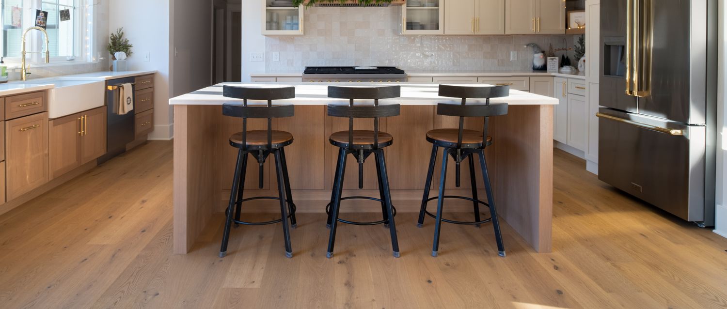Kitchen with light blond wide-plank white oak flooring and greige shaker cabinets