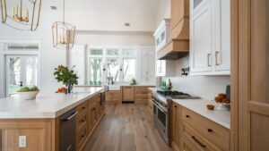 Custom kitchen with white oak cabinetry, a large island and brass pendant lighting in a Maine home