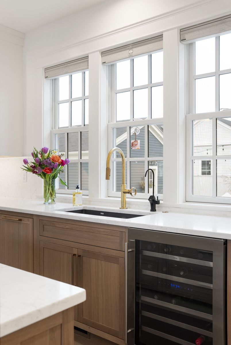 Brass bridge faucet and built-in beverage refrigerator in a Scarborough, Maine custom kitchen